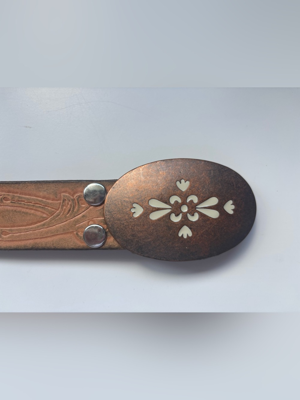 Brown leather western style belt with a copper oval buckle
